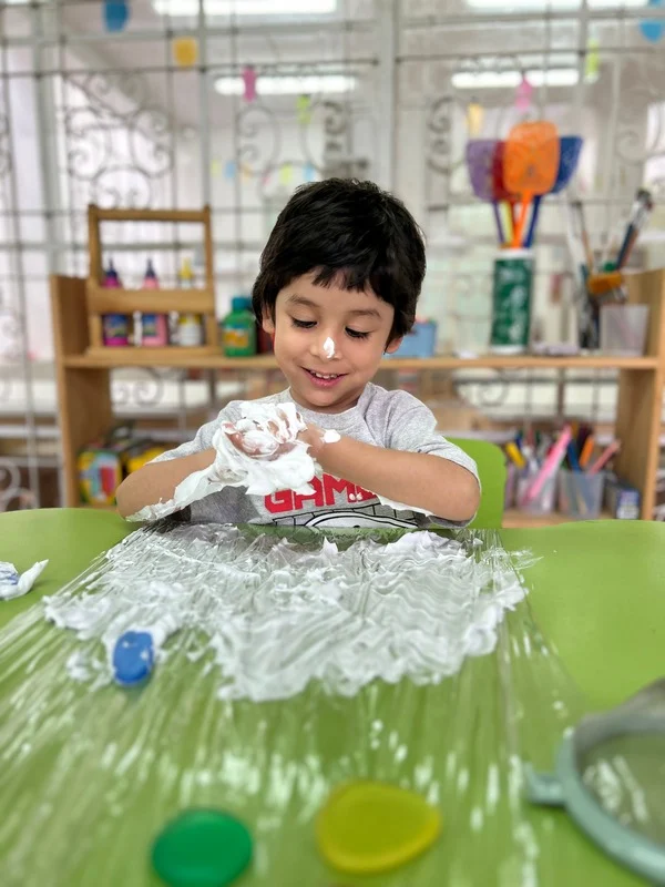 Exploración sensorial — niño jugando con espuma en el nido